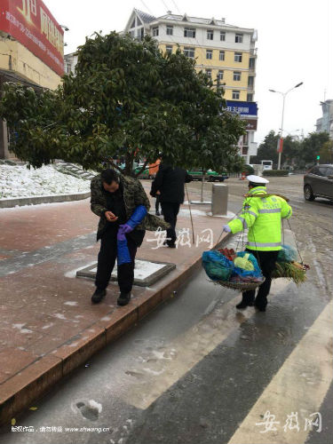 老人风雪中挑菜赶路 枞阳辅警帮忙挑担