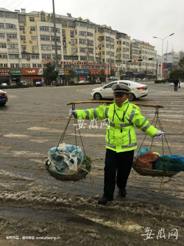 老人风雪中挑菜赶路 枞阳辅警帮忙挑担