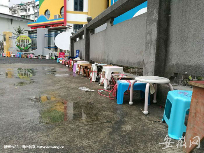 昨日，屯溪区江南实验小学幼儿园门口摆着数十张小凳子“占位”报名。