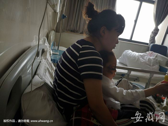 医院里，张先生的妻子抱着受伤的儿子。