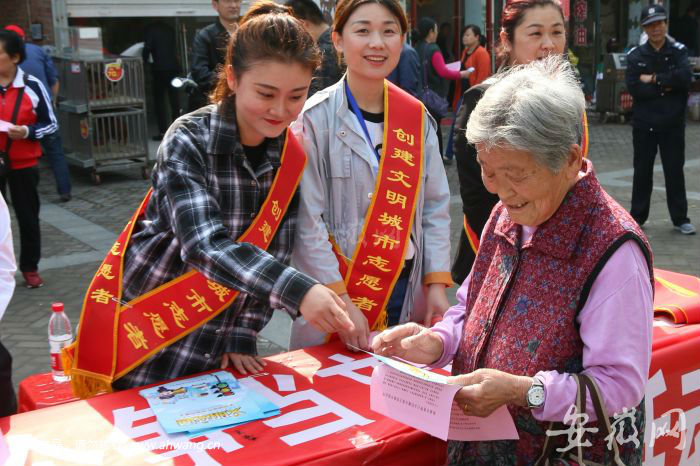 志愿者向群眾宣傳文明創(chuàng)建活動