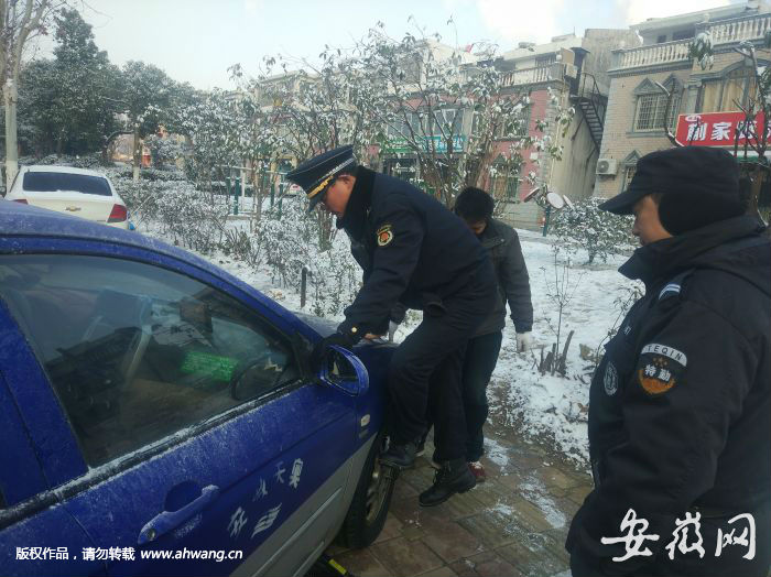 圖為城管隊員幫助出租車師傅更換輪胎
