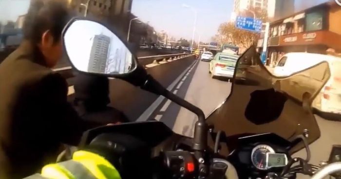 老人行走在道路中央不肯離開 交警用身軀擋車流護送
