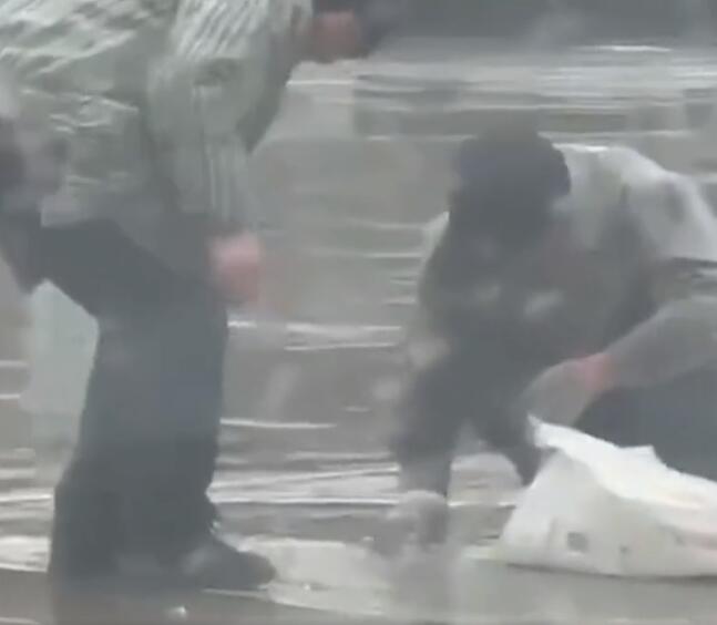淮南收废品老人路口冒雨捡拾掉落碎玻璃 怕把车胎扎破