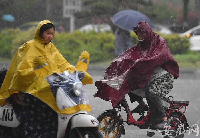 7  暴雨倾盆，市民顶着大雨行驶在路上