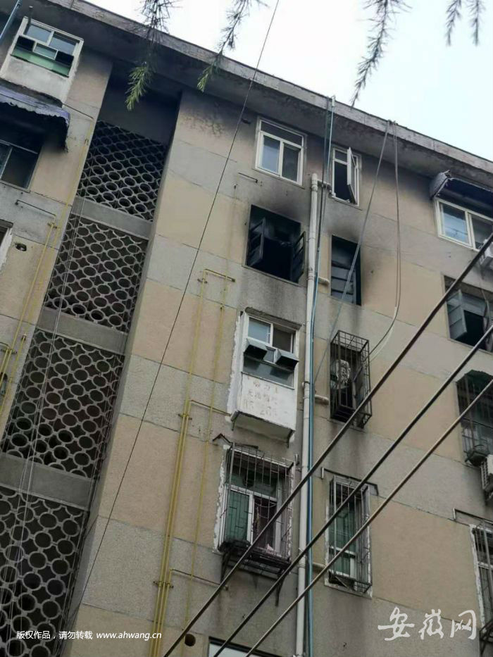 起火房屋的窗戶被濃煙熏得很黑。