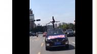 男子六安街頭站車頂玩