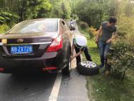 行駛中轎車車輪冒煙 旌德交警秒變“修車工”  