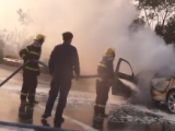 轿车行驶途中仪表盘报警后车辆自燃 阜阳消防用泡沫对车体进行覆盖
