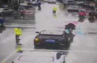 舒城街頭暖心一幕：騎電動車大姐給交警遞雨傘