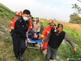 男子驾铲车侧翻至河道受伤昏迷 众人抬担架奔跑送医