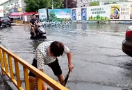 鼓掌！道路上積水嚴重，合肥這位熱心大姐自發排積水