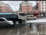 合肥临泉路与郎溪路交口大部分积水已退 环卫工人在清理路面淤泥