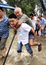 洪水中，“百医驻村”医生汤泽背起生病老人转移成“网红”