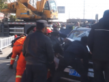 宁国：发生事故 众人合力拖出被压轿车