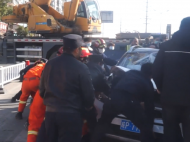 宁国：发生事故 众人合力拖出被压轿车