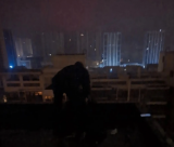 女子双脚悬空坐18楼顶平台欲轻生 淮北消防民警冒雨救助