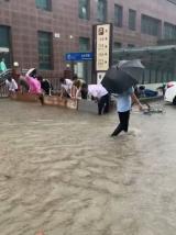 记者采访亲历郑州暴雨市民：道路积水达大腿、用簸箕清理店内积水