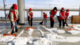 临泉高铁“志愿红”铲雪温暖回家路  