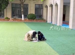 课间孩子喊住老师问问题 师生操场上席地交流
