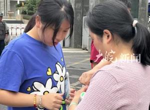 2024安徽新高考首日  合肥二中考点外妈妈 为女儿贴心拧开矿泉水瓶盖