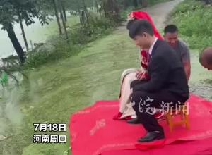 暴雨后道路积水，新郎用自制木板船接新娘，网友：千年修得同船渡