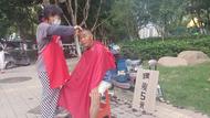?高溫下的露天工作者：街頭理發師免費為家庭困難顧客理發