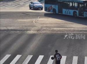 男子边打篮球边横穿马路 
后被一辆小车撞倒 
交警：人行横道不是三分线