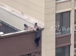 一老人悬挂22层楼顶 两名保安“钳住”胳膊 “人命关天 无论如何不会松手”