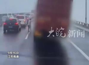 货车桥上遇台风摇摇欲坠，司机无奈奋力拉车，幸好后方大车上前挡风