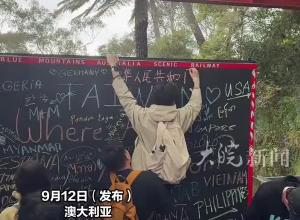 中国留学生在黑板上留言，被同伴抱起在最高处写下，“中华人民共和国 CHINA”