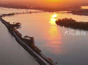 波光潋滟巢堤长 水天一色夕阳美