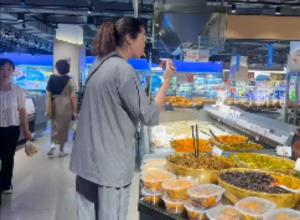 女子拿公筷夾起超市咸菜 
品嘗后又將筷子放回  
涉事門(mén)店：已將咸菜下架送檢
