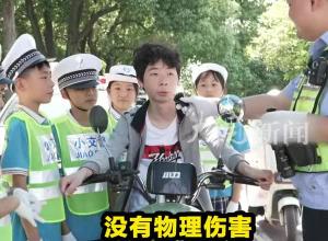 小學生體驗當交警 對騎車者不戴頭盔的行為進行“喊話式”勸導

