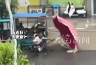 男孩冒雨幫腿腳不便老人扶雨傘