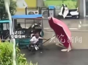 男孩冒雨幫腿腳不便老人扶雨傘