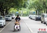 江西“90后”男生带瘫母上学：我就是妈妈的双腿
